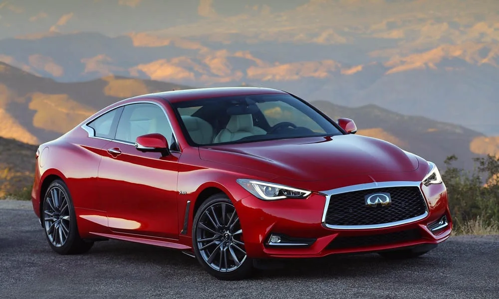 Фото Infiniti Q60 — вид спереди, фото 5. Красный кузов, строгая симметрия оптики — базовый ракурс знакомства с дизайном. Дневные ходовые огни включаются автоматически с запуском Infiniti Q60 — вид спереди, фото 5