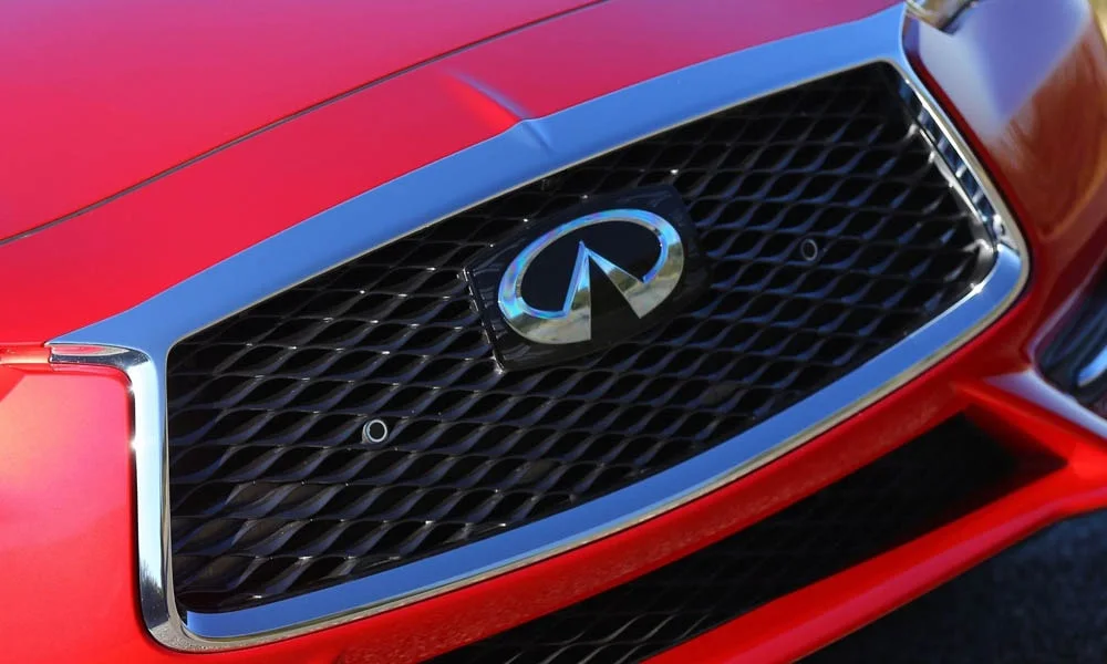 Фото Infiniti Q60 — вид спереди, фото 11. Красный кузов, строгая симметрия оптики — базовый ракурс знакомства с дизайном. Рисунок ходовых огней — подпись модели, по нему её узнают в потоке Infiniti Q60 — вид спереди, фото 11