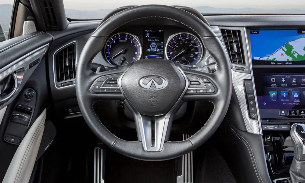 Фото Infiniti Q60 — руль. Обшивка обода и компоновка спиц крупным планом. Обогрев обода — опция, которую оценят зимой Infiniti Q60 — руль