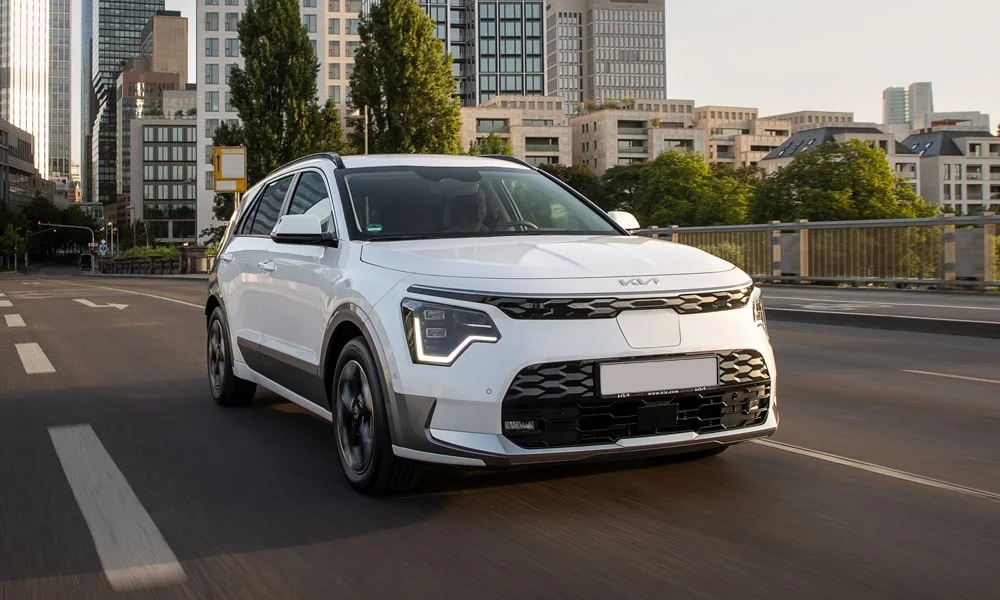 Фото KIA Niro — вид спереди, фото 10. Белый кузов, строгая симметрия оптики — базовый ракурс знакомства с дизайном. Рисунок ходовых огней — подпись модели, по нему её узнают в потоке KIA Niro — вид спереди, фото 10