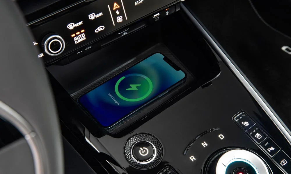 Фото KIA Niro — беспроводная зарядка. Площадка для смартфона: зарядка без проводов. Прорезиненное покрытие удерживает телефон в поворотах; мощность зарядки — в характеристиках версии KIA Niro — беспроводная зарядка