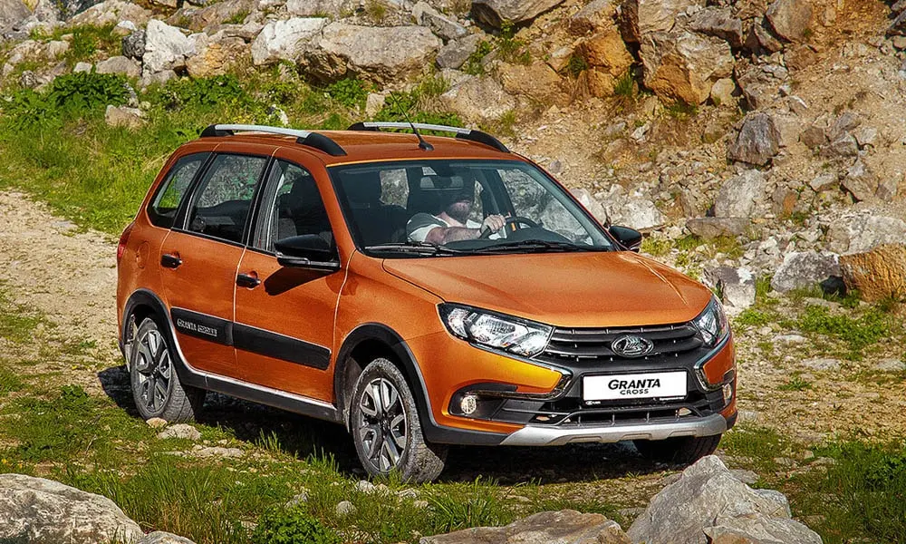 Фото LADA Granta Cross — вид спереди, фото 8. Передок в оранжевом исполнении — крупная светотехника и выразительный бампер. Рисунок ходовых огней — подпись модели, по нему её узнают в потоке LADA Granta Cross — вид спереди, фото 8