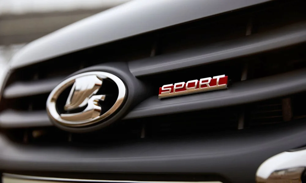 Фото LADA Granta Sport Лифтбек (2023) — эмблема. Фирменный шильдик на кузове — знак принадлежности к марке. Шильдик версии на корме помогает отличать комплектации LADA Granta Sport Лифтбек (2023) — эмблема