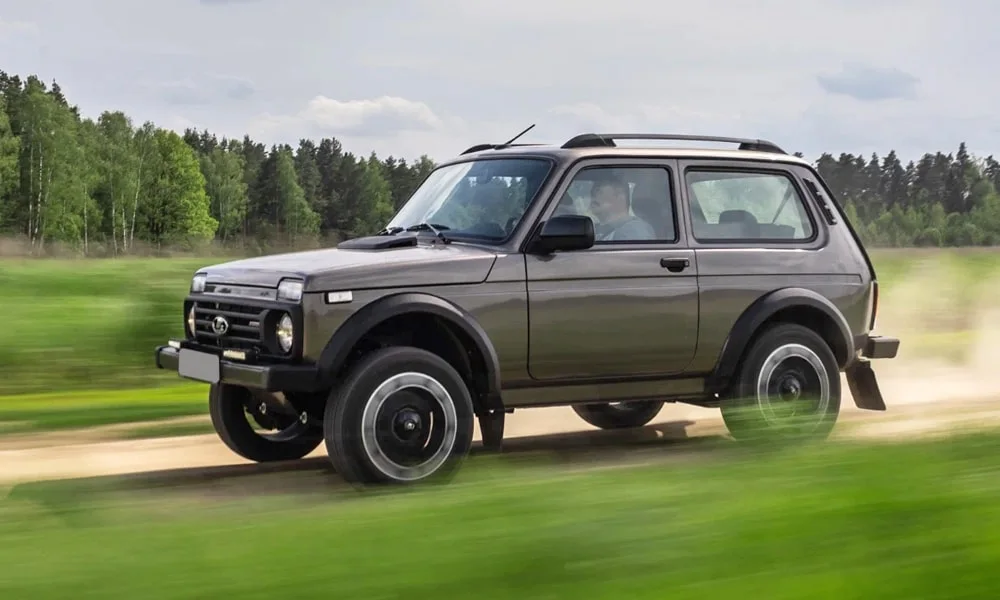 Фото LADA Niva Sport (2025) — вид спереди, фото 5. Передок в коричневом исполнении — крупная светотехника и выразительный бампер. Рисунок ходовых огней — подпись модели, по нему её узнают в потоке LADA Niva Sport (2025) — вид спереди, фото 5