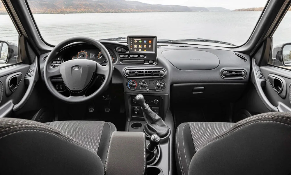 Фото LADA Niva Travel (2025) — передняя панель. Передняя панель в тёмной отделке: расположение экранов и дефлекторов. Минимум физических кнопок — ставка на экранное управление LADA Niva Travel (2025) — передняя панель