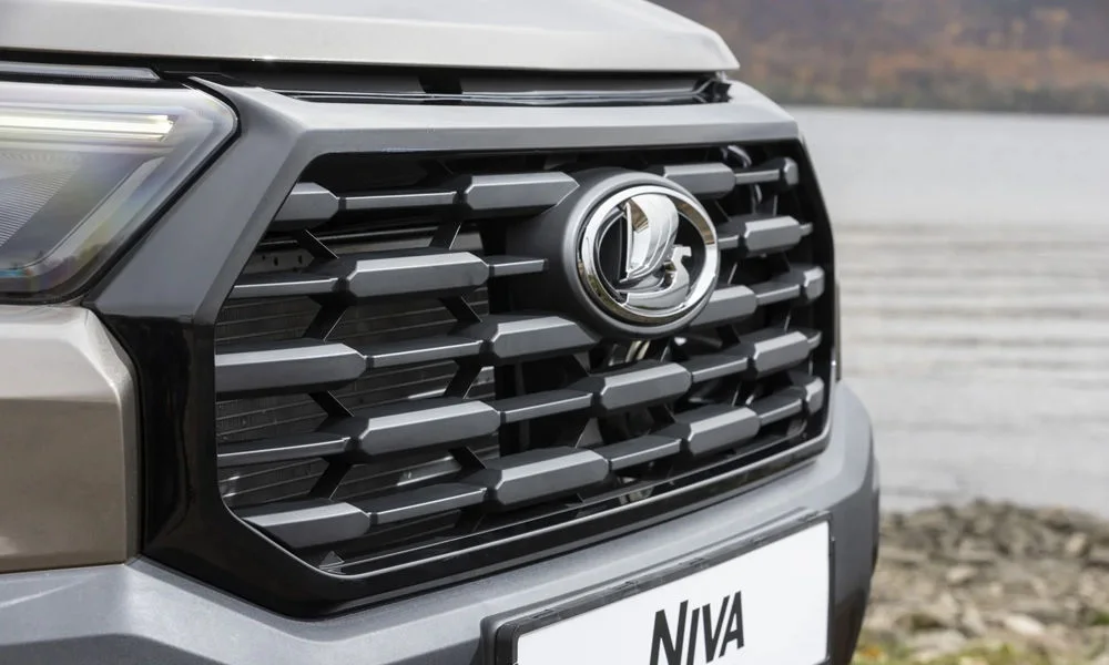 Фото LADA Niva Travel (2025) — решётка радиатора. Рисунок решётки: сетка, ламели или глухая панель у электроверсий. Активные жалюзи за решёткой закрываются на трассе ради аэродинамики — есть у ряда моделей LADA Niva Travel (2025) — решётка радиатора