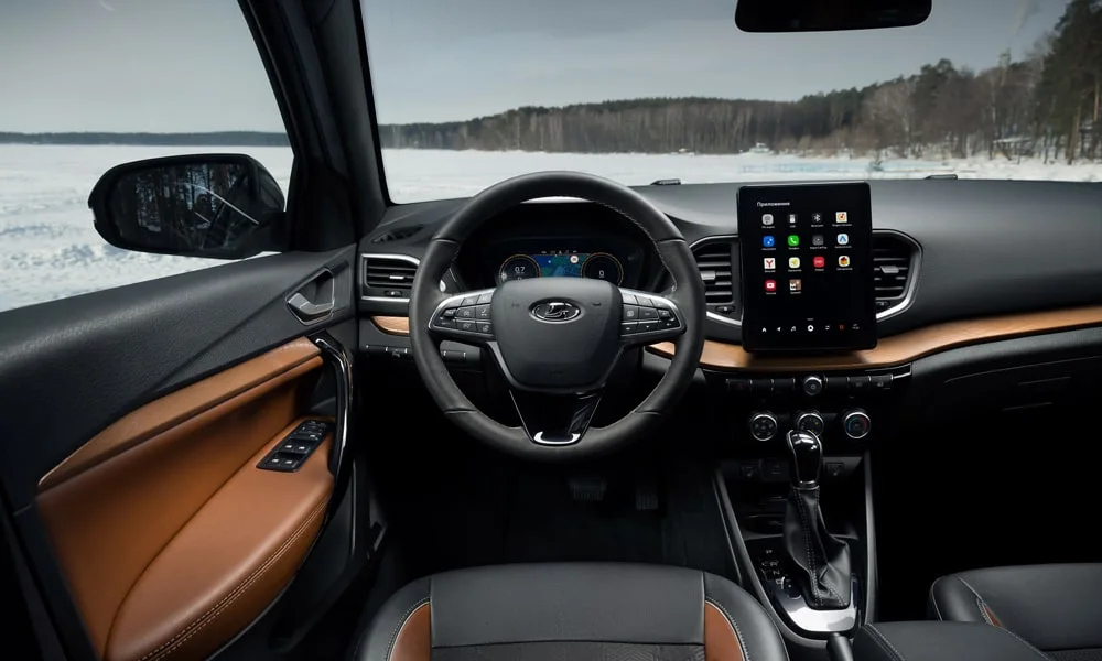 Фото LADA Vesta Cross (2023) — передняя панель. Панель в коричневой отделке — видна компоновка экранов и органов управления. Минимум физических кнопок — ставка на экранное управление LADA Vesta Cross (2023) — передняя панель