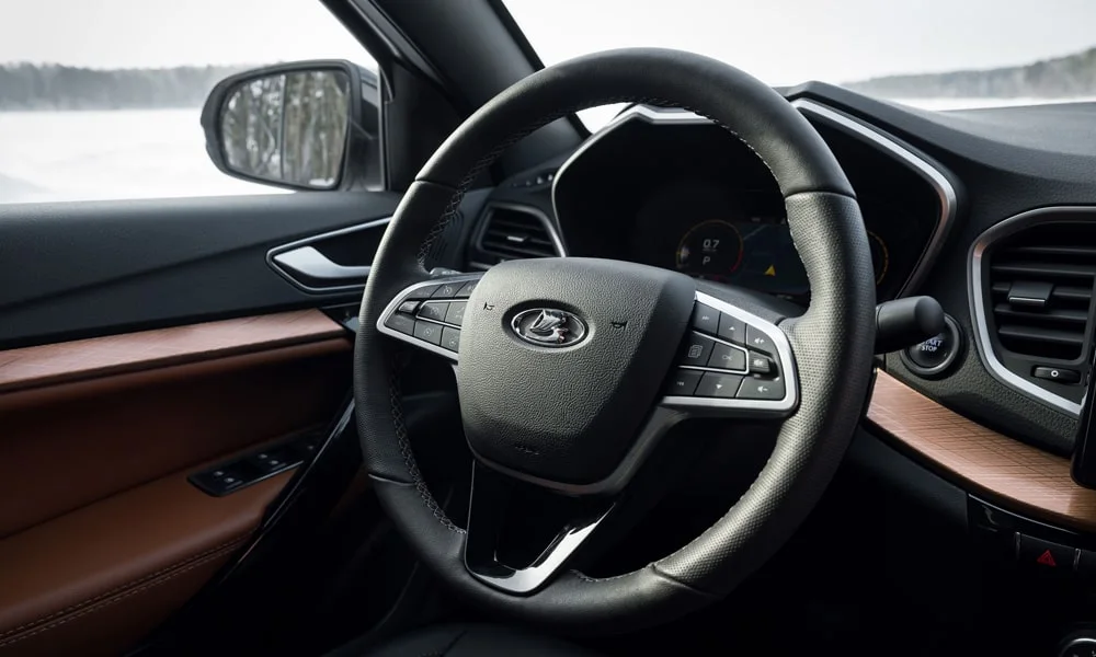 Фото LADA Vesta Cross (2023) — руль. Обшивка обода и компоновка спиц крупным планом. Правильная посадка: руки на «9 и 3», приборы читаются поверх обода LADA Vesta Cross (2023) — руль