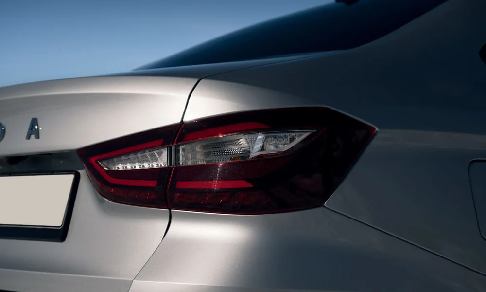 Фото LADA Vesta Cross (2023) — задние фонари. Рассеиватель фонаря вблизи: компоновка секций габарита, стопа и поворотника. Динамические поворотники с бегущей индикацией встречаются в старших комплектациях LADA Vesta Cross (2023) — задние фонари