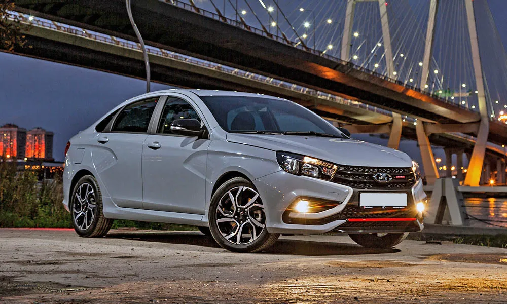 Фото LADA Vesta Sport (2026) — вид спереди, фото 7. Передок в белом исполнении — крупная светотехника и выразительный бампер. Рисунок ходовых огней — подпись модели, по нему её узнают в потоке LADA Vesta Sport (2026) — вид спереди, фото 7