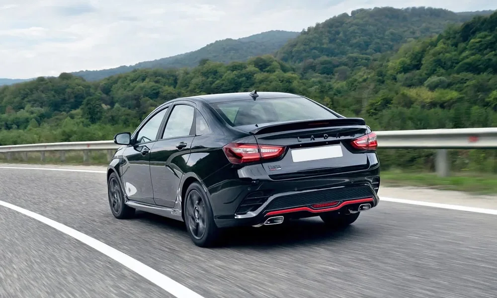 Фото LADA Vesta Sportline (2023) — вид сзади, фото 4. Корма в чёрном цвете: графика фонарей и пластика пятой двери. Насадки выхлопа или их имитация внизу бампера различают версии LADA Vesta Sportline (2023) — вид сзади, фото 4
