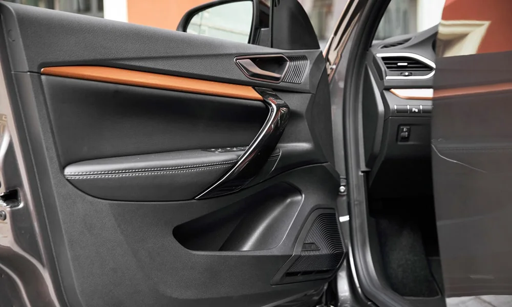 Фото LADA Vesta SW Cross (2023) — дверная карта. Дверная карта в коричневой отделке: подлокотник, динамик и блок стеклоподъёмников. Мягкая вставка в зоне локтя — то, что чувствуешь каждый день LADA Vesta SW Cross (2023) — дверная карта