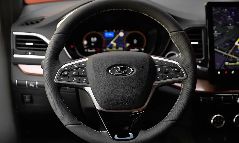Фото LADA Vesta SW Cross (2023) — руль. Обшивка обода и компоновка спиц крупным планом. Клавиши на спицах управляют медиа, круизом и ассистентами — руки остаются на руле LADA Vesta SW Cross (2023) — руль