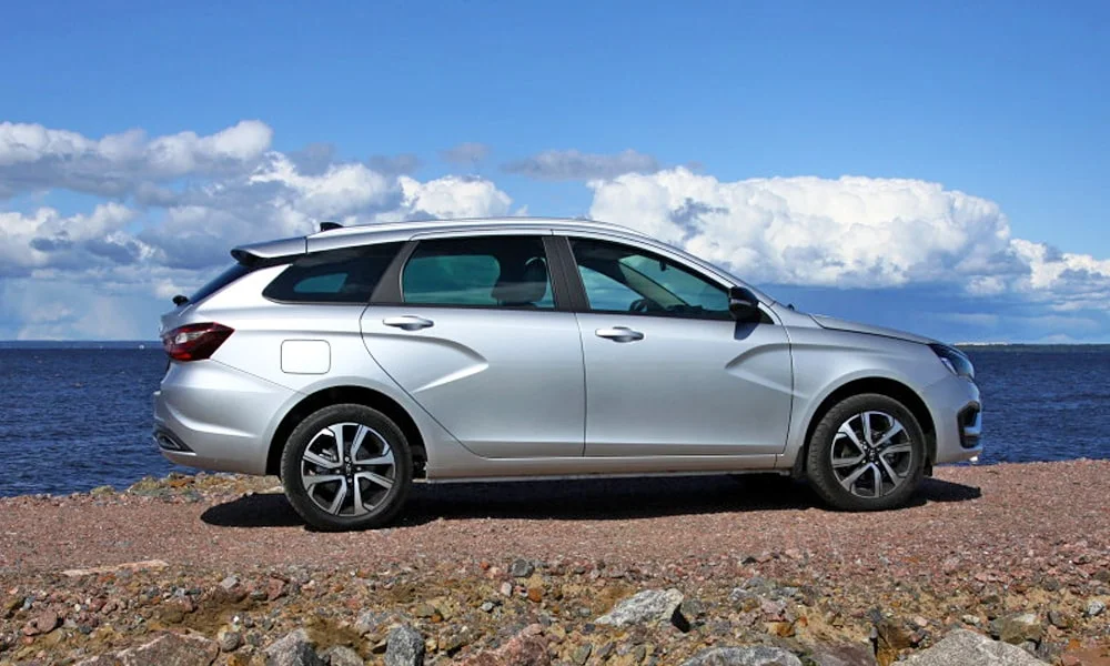 Фото LADA Vesta SW (2023) — вид сбоку, фото 5. Серебристый кузов в профиль — пропорции, высота посадки и дизайн дисков. Хромированные или чёрные молдинги окон отличают комплектации LADA Vesta SW (2023) — вид сбоку, фото 5