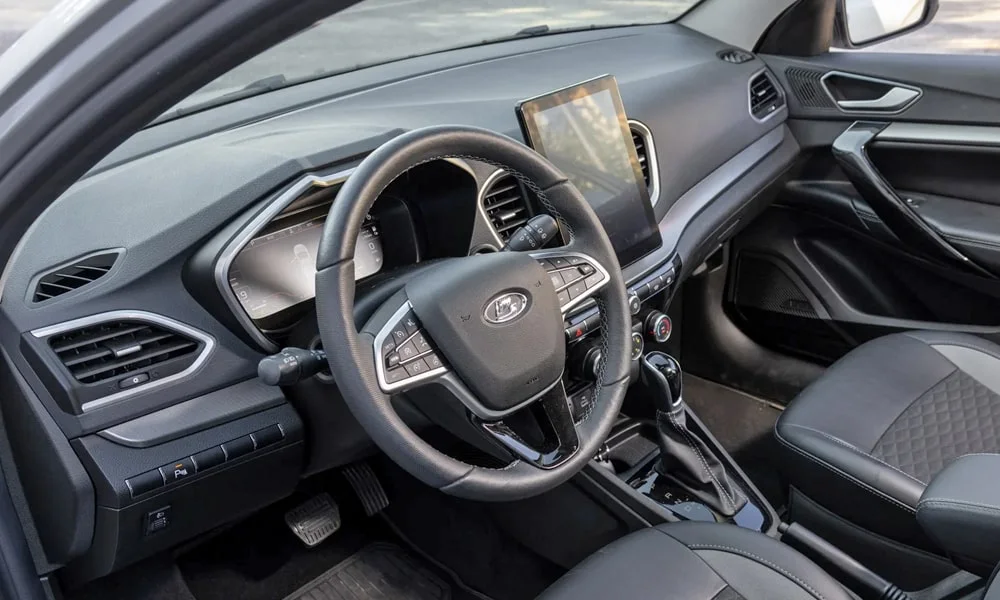 Фото LADA Vesta SW (2023) — руль. Обшивка обода и компоновка спиц крупным планом. Клавиши на спицах управляют медиа, круизом и ассистентами — руки остаются на руле LADA Vesta SW (2023) — руль