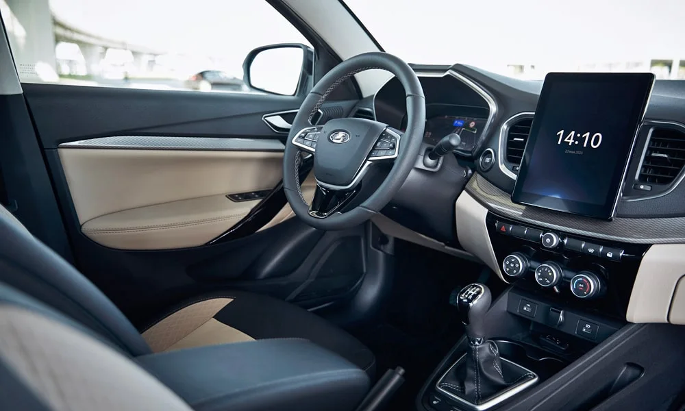 Фото LADA Vesta (2023) — передняя панель. Архитектура передней панели: ярусы, вставки и консоль в светлой бежевой гамме. Мягкие материалы верхнего яруса и вставки задают уровень интерьера LADA Vesta (2023) — передняя панель