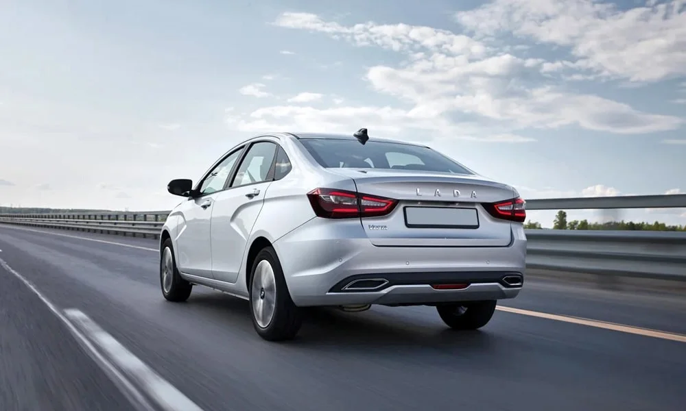 Фото LADA Vesta (2023) — вид сзади, фото 5. Серебристый кузов сзади — фонари и бампер определяют ночной образ модели. Светодиодная полоса или раздельные секции — задняя оптика стала главным украшением кормы LADA Vesta (2023) — вид сзади, фото 5