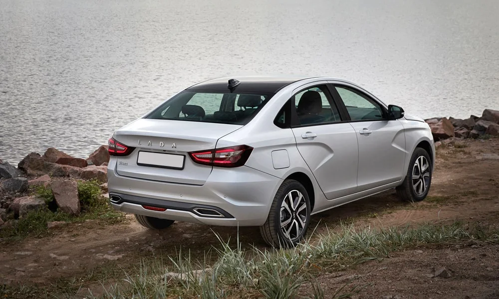 Фото LADA Vesta (2023) — вид сзади, фото 8. Серебристый кузов сзади — фонари и бампер определяют ночной образ модели LADA Vesta (2023) — вид сзади, фото 8