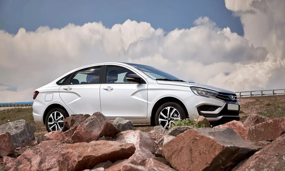 Фото LADA Vesta (2023) — вид сбоку, фото 3. Белый кузов в профиль — пропорции, высота посадки и дизайн дисков LADA Vesta (2023) — вид сбоку, фото 3