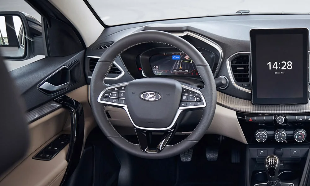 Фото LADA Vesta (2023) — руль. Обшивка обода и компоновка спиц крупным планом. Клавиши на спицах управляют медиа, круизом и ассистентами — руки остаются на руле LADA Vesta (2023) — руль