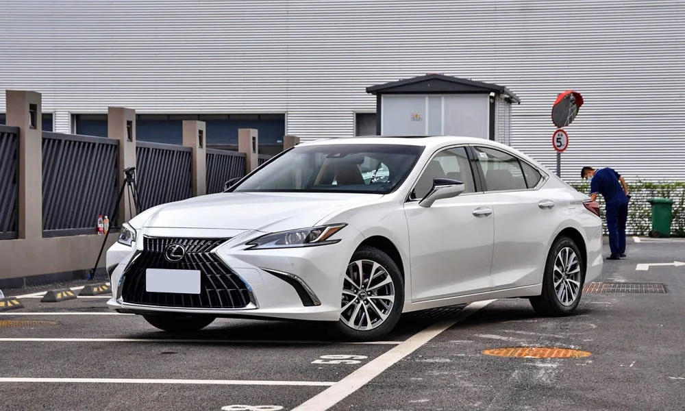 Фото Lexus ES 200 — вид спереди, фото 3. Белый кузов, строгая симметрия оптики — базовый ракурс знакомства с дизайном. Дневные ходовые огни включаются автоматически с запуском Lexus ES 200 — вид спереди, фото 3