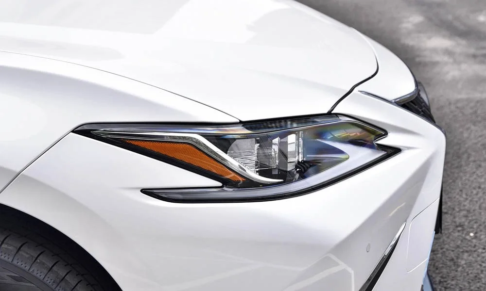 Фото Lexus ES 200 — передняя оптика. Фара вблизи — самый детализированный элемент экстерьера. Светодиодная оптика служит весь срок жизни машины без замены ламп Lexus ES 200 — передняя оптика
