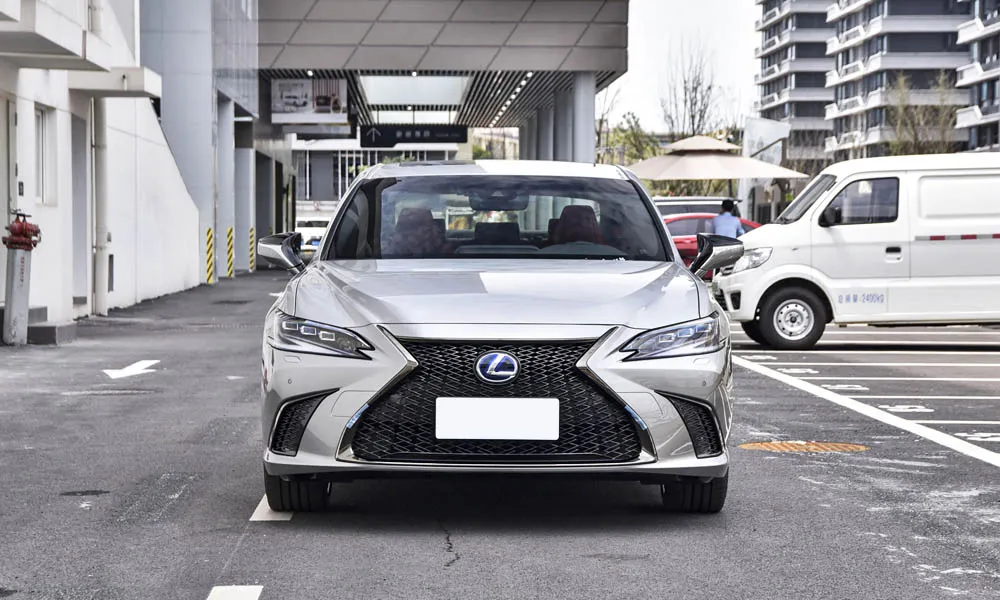 Фото Lexus ES 250 — вид спереди, фото 5. Серебристый кузов, строгая симметрия оптики — базовый ракурс знакомства с дизайном. Дневные ходовые огни включаются автоматически с запуском Lexus ES 250 — вид спереди, фото 5