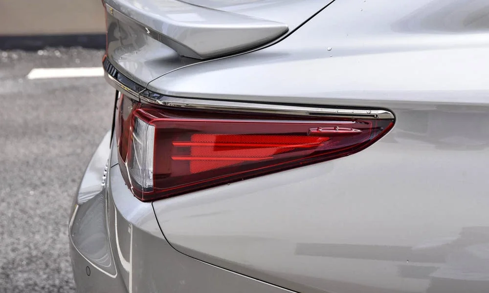 Фото Lexus ES 250 — задние фонари. Графика секций крупным планом — ночная подпись модели. Динамические поворотники с бегущей индикацией встречаются в старших комплектациях Lexus ES 250 — задние фонари