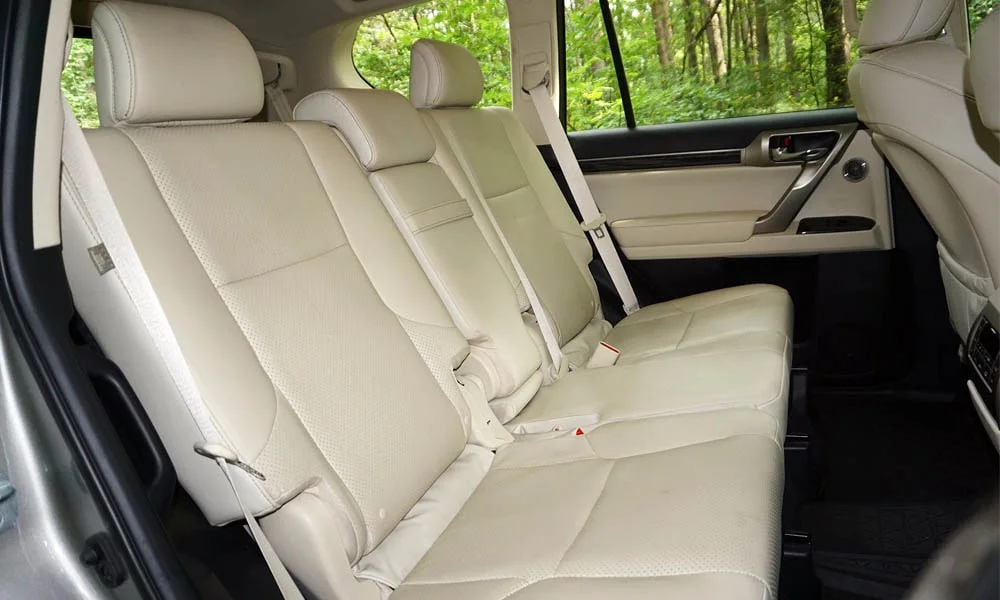 Фото Lexus GX 460 — задние сиденья, фото 3. Посадка второго ряда: подголовники и подлокотник. Крепления ISOFIX для детских кресел — в основании спинки Lexus GX 460 — задние сиденья, фото 3
