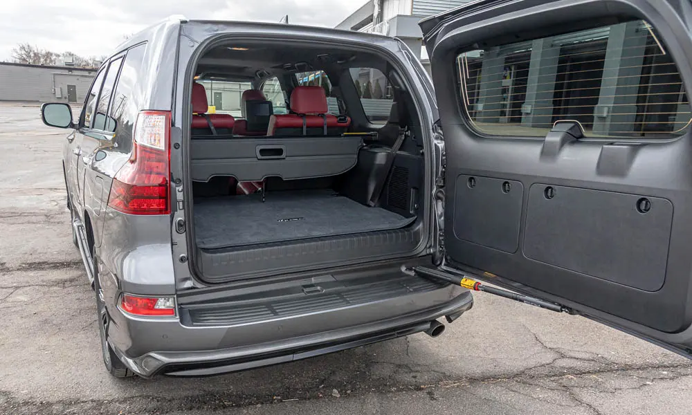 Фото Lexus GX 460 — багажник. Грузовой отсек с открытой дверью: погрузочная высота и ширина проёма. Спинки второго ряда складываются и расширяют отсек под длинные грузы Lexus GX 460 — багажник