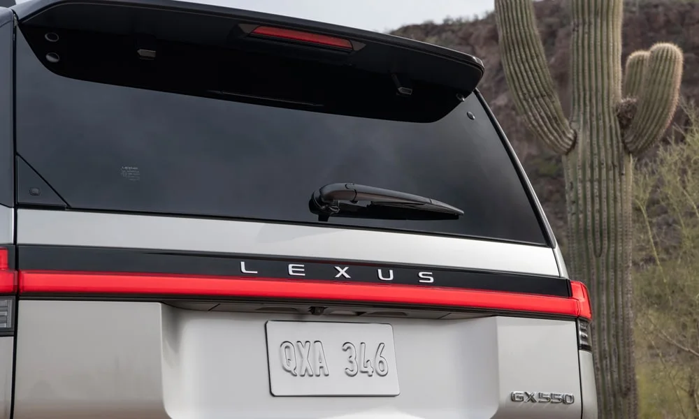 Фото Lexus GX 550 (2024) — вид сзади, фото 4. Серебристый кузов сзади — фонари и бампер определяют ночной образ модели. Насадки выхлопа или их имитация внизу бампера различают версии Lexus GX 550 (2024) — вид сзади, фото 4