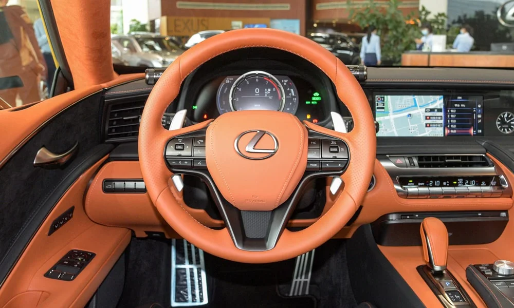 Фото Lexus LC 500 — руль. Обшивка обода и компоновка спиц крупным планом. Правильная посадка: руки на «9 и 3», приборы читаются поверх обода Lexus LC 500 — руль