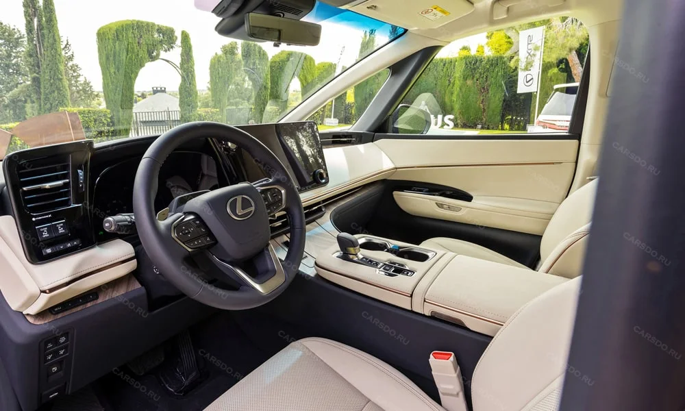 Фото Lexus LM 350 (2024) — передняя панель. Панель в светлой бежевой отделке — видна компоновка экранов и органов управления. Минимум физических кнопок — ставка на экранное управление Lexus LM 350 (2024) — передняя панель