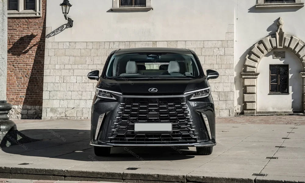Фото Lexus LM 350 (2024) — вид спереди, фото 9. Чёрный кузов, строгая симметрия оптики — базовый ракурс знакомства с дизайном. Рисунок ходовых огней — подпись модели, по нему её узнают в потоке Lexus LM 350 (2024) — вид спереди, фото 9