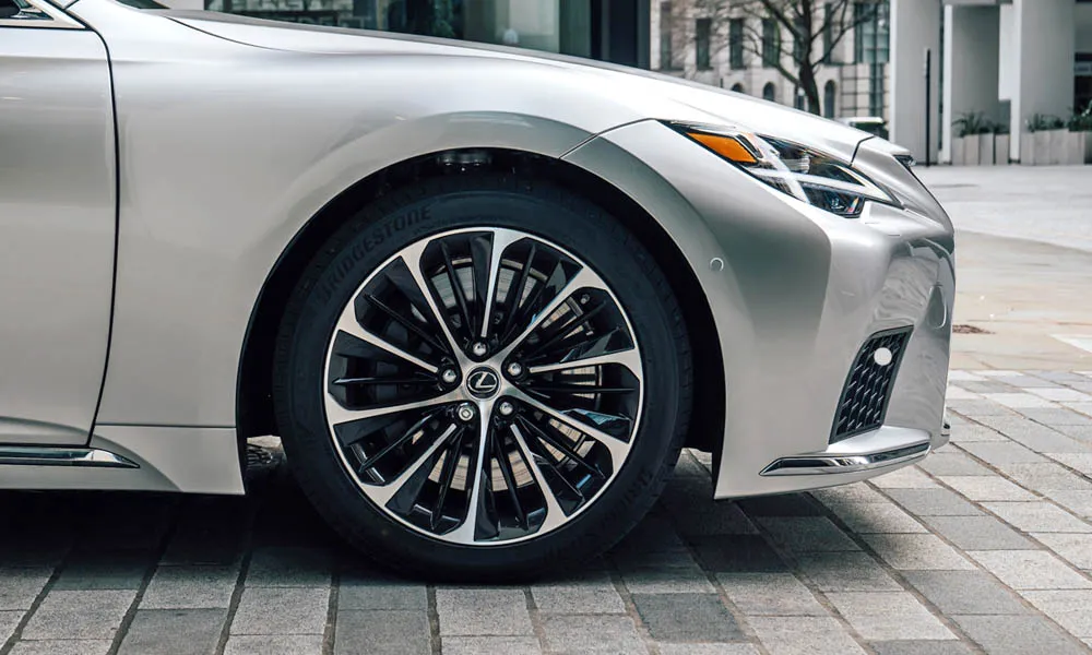 Фото Lexus LS 350 — вид спереди, фото 5. Передок в серебристом исполнении — крупная светотехника и выразительный бампер. Рисунок ходовых огней — подпись модели, по нему её узнают в потоке Lexus LS 350 — вид спереди, фото 5