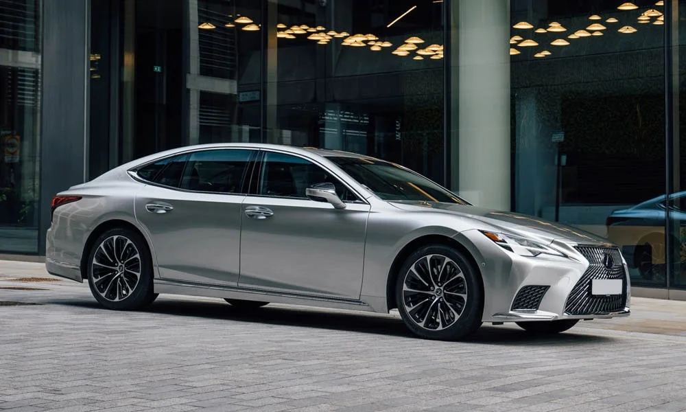 Фото Lexus LS 350 — вид спереди, фото 9. Серебристый кузов, строгая симметрия оптики — базовый ракурс знакомства с дизайном. Дневные ходовые огни включаются автоматически с запуском Lexus LS 350 — вид спереди, фото 9