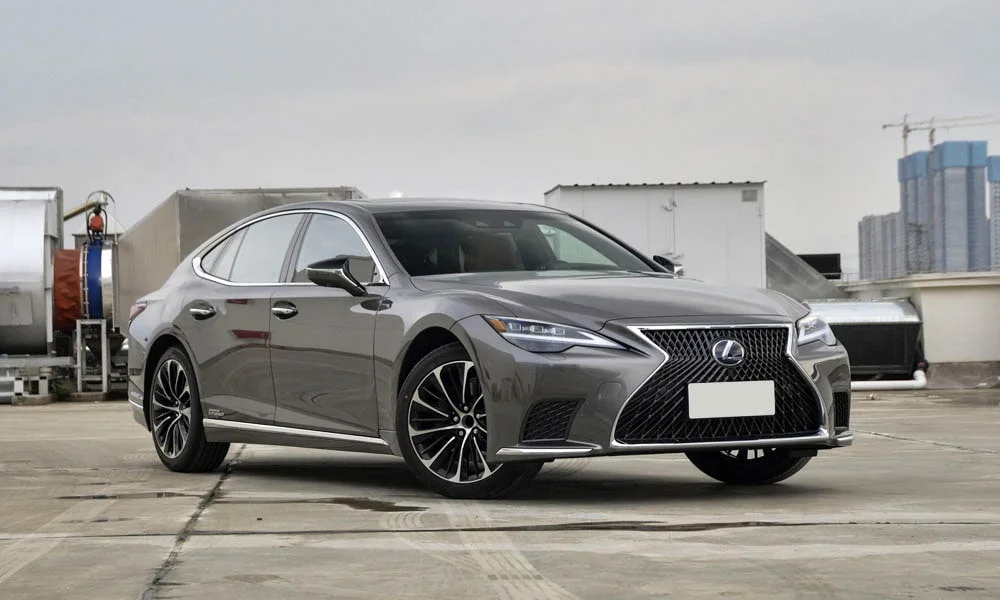 Фото Lexus LS 500 — вид спереди, фото 3. Серый кузов, строгая симметрия оптики — базовый ракурс знакомства с дизайном. Дневные ходовые огни включаются автоматически с запуском Lexus LS 500 — вид спереди, фото 3
