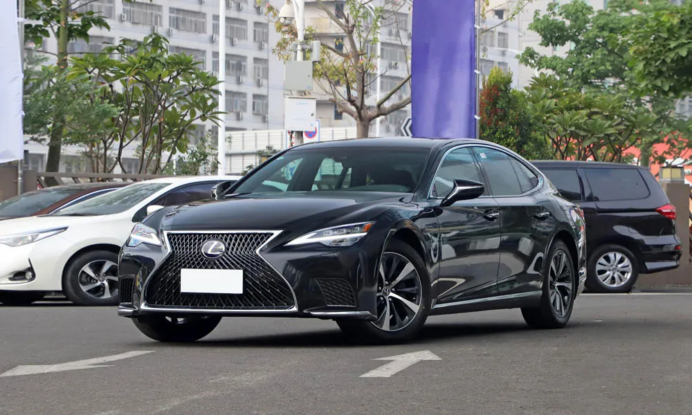 Фото Lexus LS 500 — вид спереди, фото 6. Чёрный кузов, строгая симметрия оптики — базовый ракурс знакомства с дизайном. Рисунок ходовых огней — подпись модели, по нему её узнают в потоке Lexus LS 500 — вид спереди, фото 6
