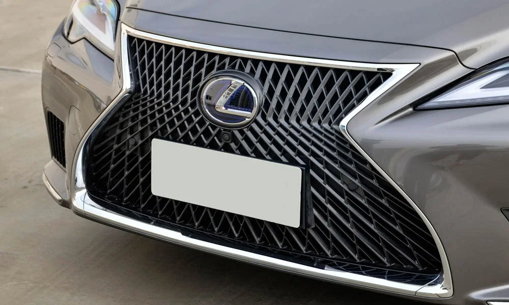 Фото Lexus LS 500 — решётка радиатора. Рисунок решётки: сетка, ламели или глухая панель у электроверсий. Активные жалюзи за решёткой закрываются на трассе ради аэродинамики — есть у ряда моделей Lexus LS 500 — решётка радиатора