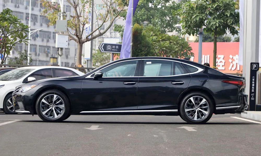 Фото Lexus LS 500 — вид сбоку, фото 2. Чёрный кузов в профиль — пропорции, высота посадки и дизайн дисков. Длинная база — простор второго ряда; короткие свесы упрощают парковку Lexus LS 500 — вид сбоку, фото 2