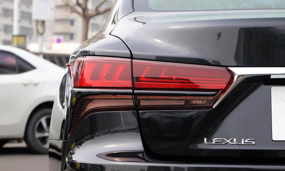 Фото Lexus LS 500 — задние фонари. Рассеиватель фонаря вблизи: компоновка секций габарита, стопа и поворотника. Динамические поворотники с бегущей индикацией встречаются в старших комплектациях Lexus LS 500 — задние фонари