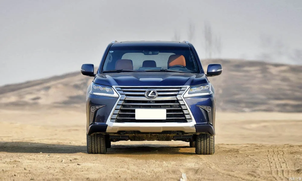 Фото Lexus LX 450d — вид спереди, фото 7. Оптика, решётка и бампер — первое впечатление о модели. Рисунок ходовых огней — подпись модели, по нему её узнают в потоке Lexus LX 450d — вид спереди, фото 7