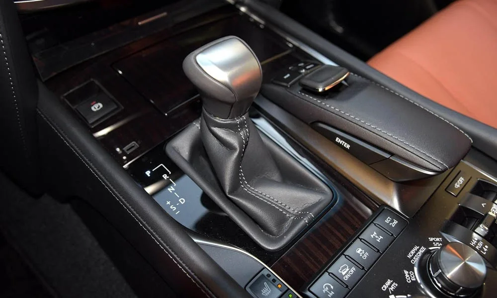 Фото Lexus LX 450d — селектор коробки передач. Управление коробкой: компактный селектор освобождает место на тоннеле. Режимы движения и электронный ручник собраны рядом с селектором Lexus LX 450d — селектор коробки передач