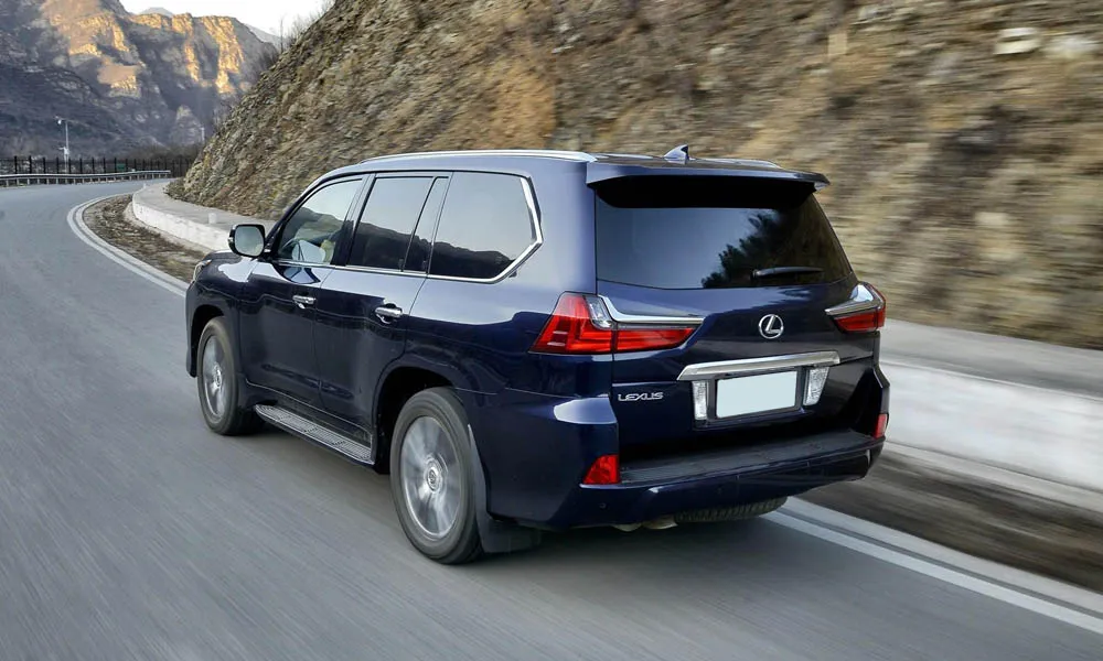 Фото Lexus LX 450d — вид сзади, фото 5. Корма в синем цвете: графика фонарей и пластика пятой двери. Насадки выхлопа или их имитация внизу бампера различают версии Lexus LX 450d — вид сзади, фото 5
