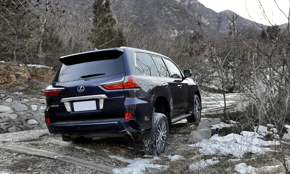 Фото Lexus LX 450d — вид сзади, фото 6. Корма в чёрном цвете: графика фонарей и пластика пятой двери. Светодиодная полоса или раздельные секции — задняя оптика стала главным украшением кормы Lexus LX 450d — вид сзади, фото 6
