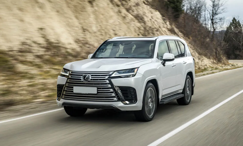 Фото Lexus LX 500d (2022) — вид спереди, фото 4. Белый кузов, строгая симметрия оптики — базовый ракурс знакомства с дизайном Lexus LX 500d (2022) — вид спереди, фото 4