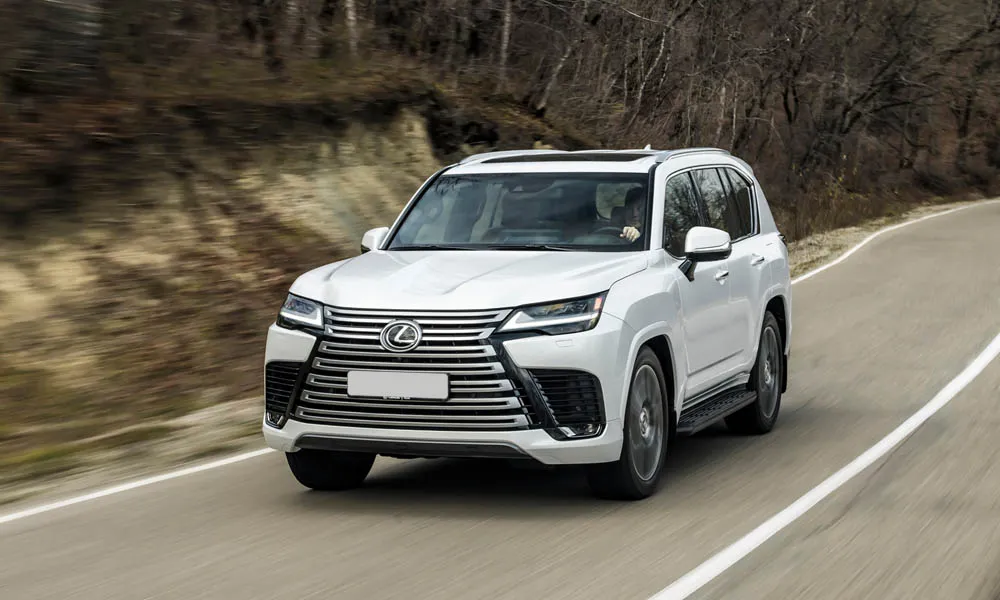 Фото Lexus LX 500d (2022) — вид спереди, фото 6. Кузов в белом цвете: рисунок оптики и решётки задаёт узнаваемое «лицо» модели Lexus LX 500d (2022) — вид спереди, фото 6