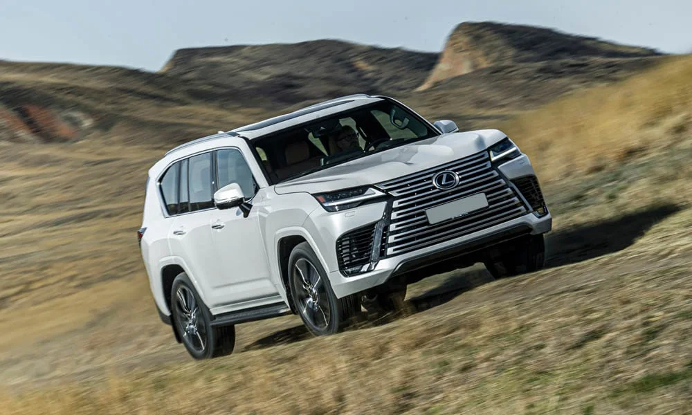 Фото Lexus LX 500d (2022) — вид спереди, фото 9. Анфас: пропорции капота, посадка кузова и графика ходовых огней. Рисунок ходовых огней — подпись модели, по нему её узнают в потоке Lexus LX 500d (2022) — вид спереди, фото 9