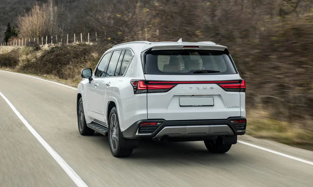 Фото Lexus LX 500d (2022) — вид сзади, фото 3. Корма в белом цвете: графика фонарей и пластика пятой двери. Насадки выхлопа или их имитация внизу бампера различают версии Lexus LX 500d (2022) — вид сзади, фото 3