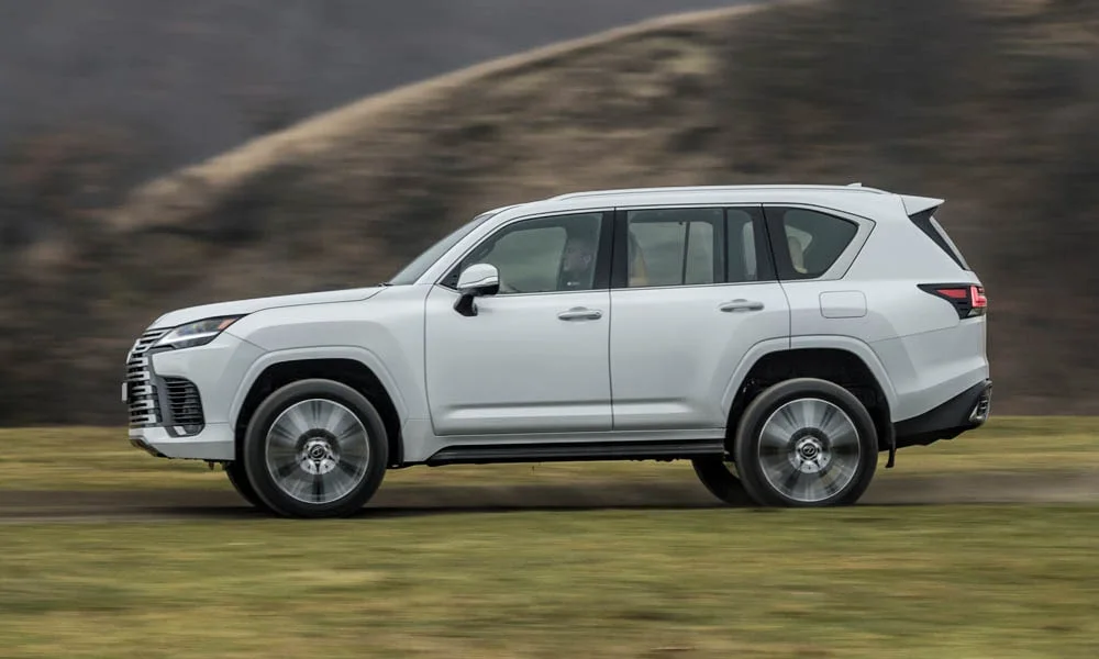 Фото Lexus LX 500d (2022) — вид сбоку, фото 2. Профиль кузова: колёсная база, свесы и линия остекления. Хромированные или чёрные молдинги окон отличают комплектации Lexus LX 500d (2022) — вид сбоку, фото 2